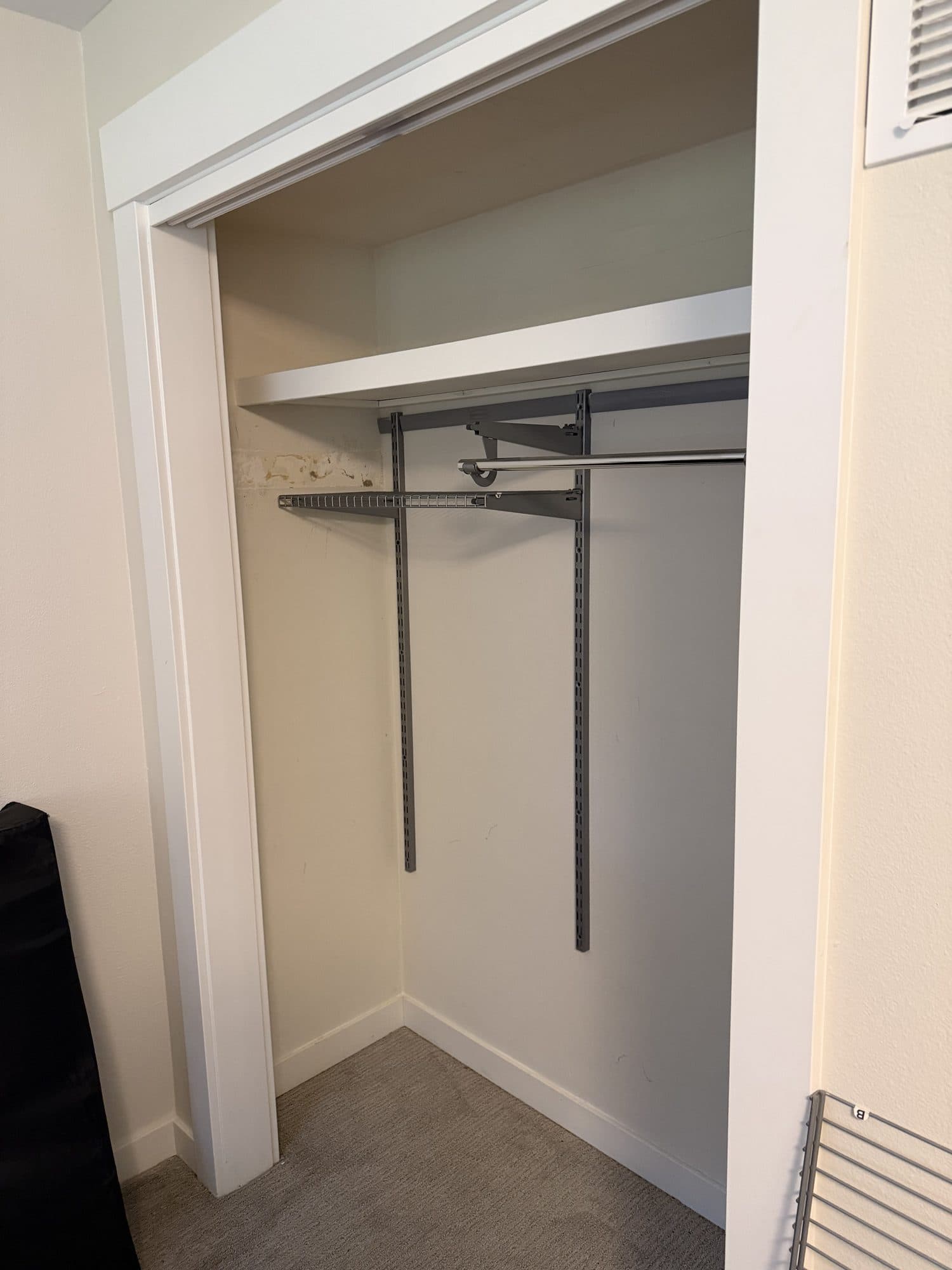 The empty closet with its hanging rails still mounted