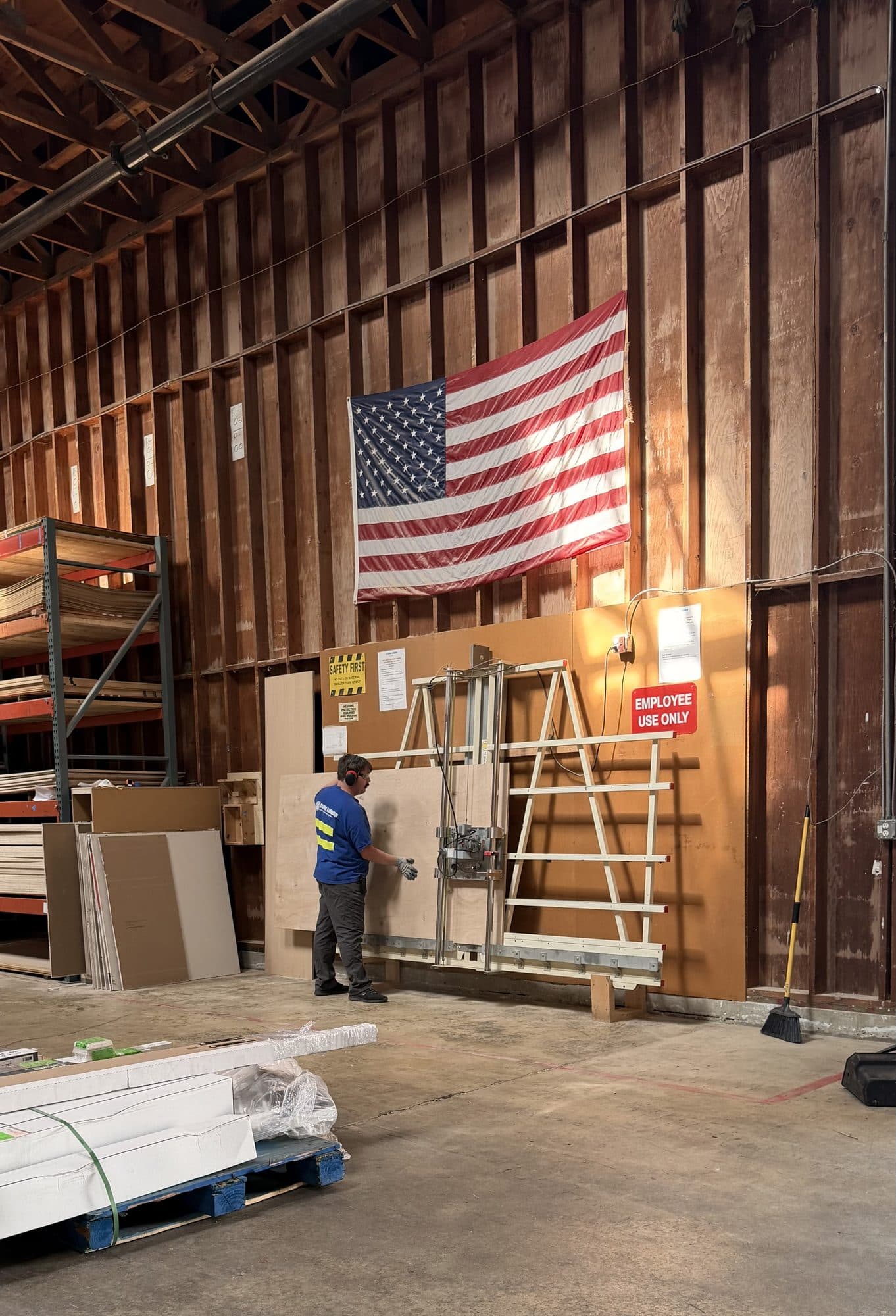 A sheet of plywood being cut to size on the panel saw at the lumber yard