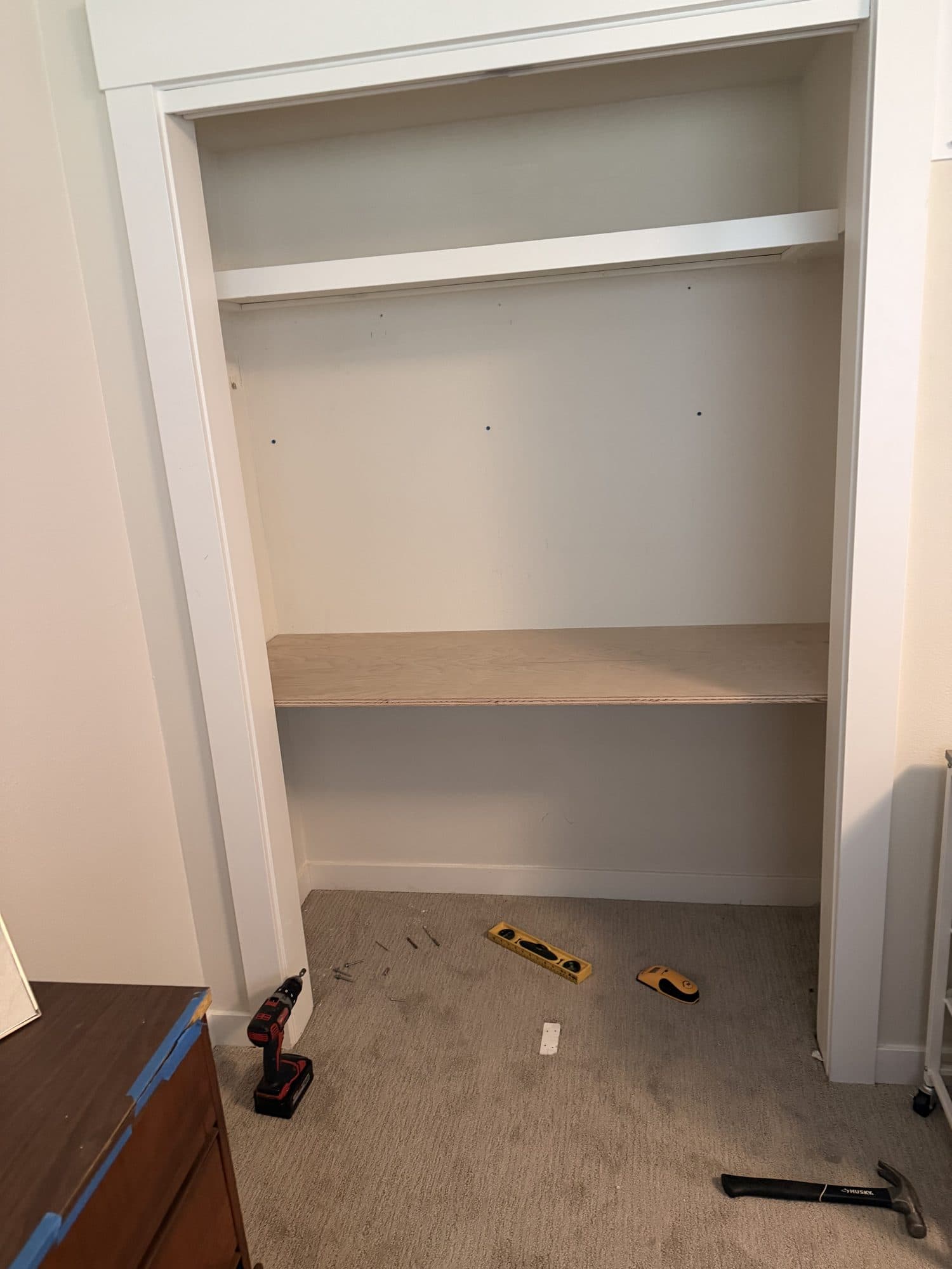 The rails removed and a plywood desktop being fitted, tools on the floor