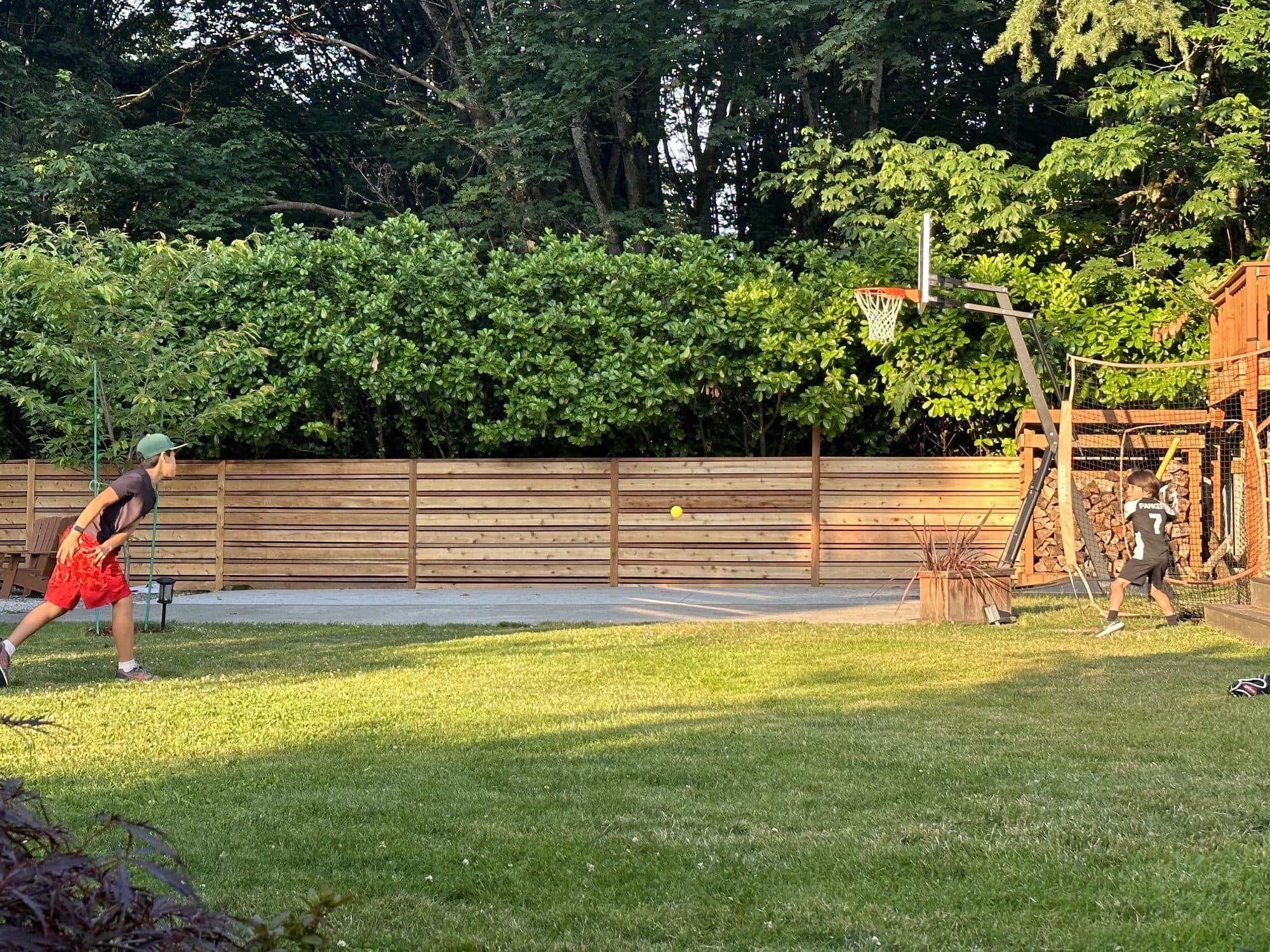 Kids playing ball in the fenced yard