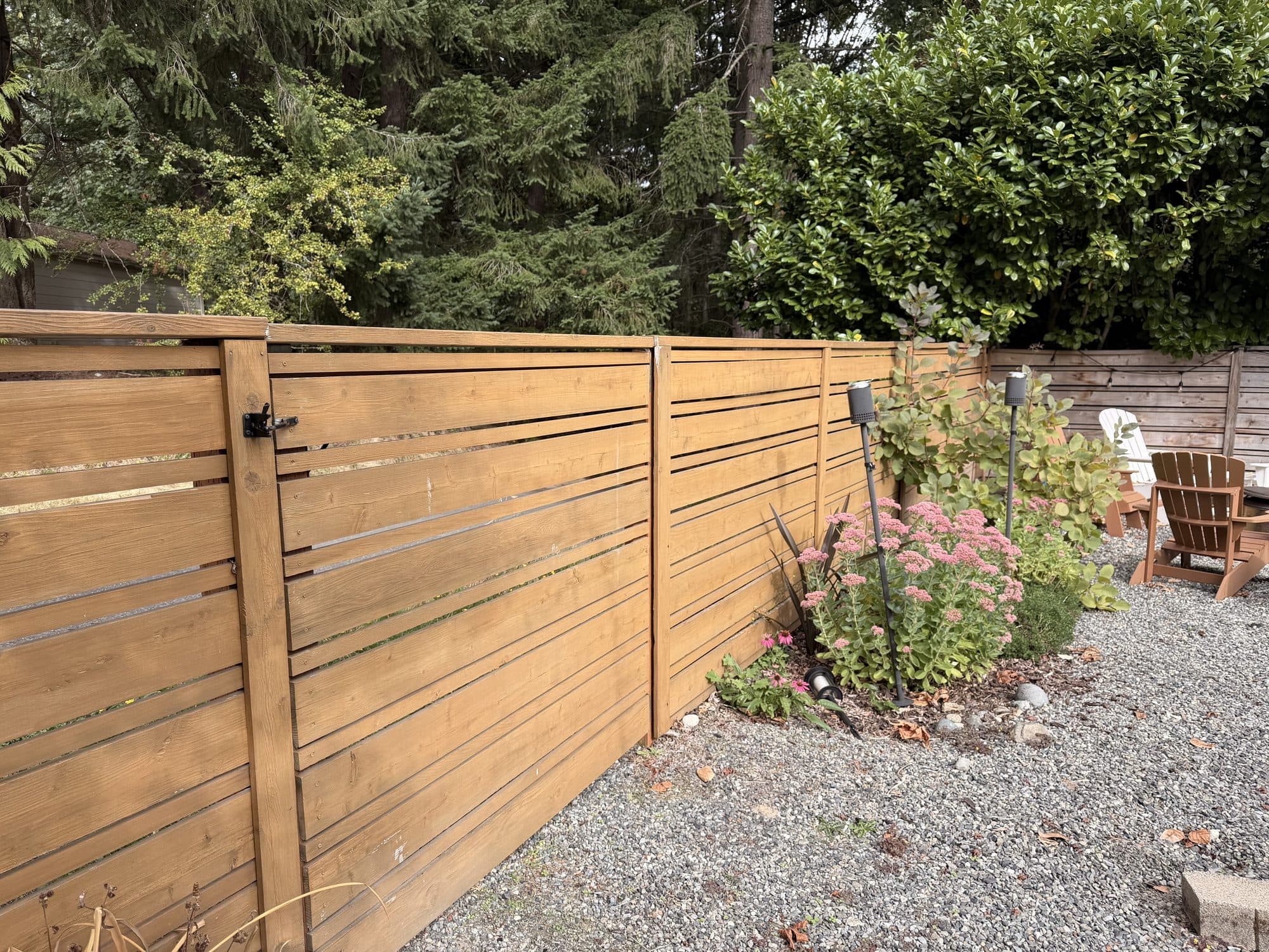 The finished horizontal cedar fence along the side of the yard