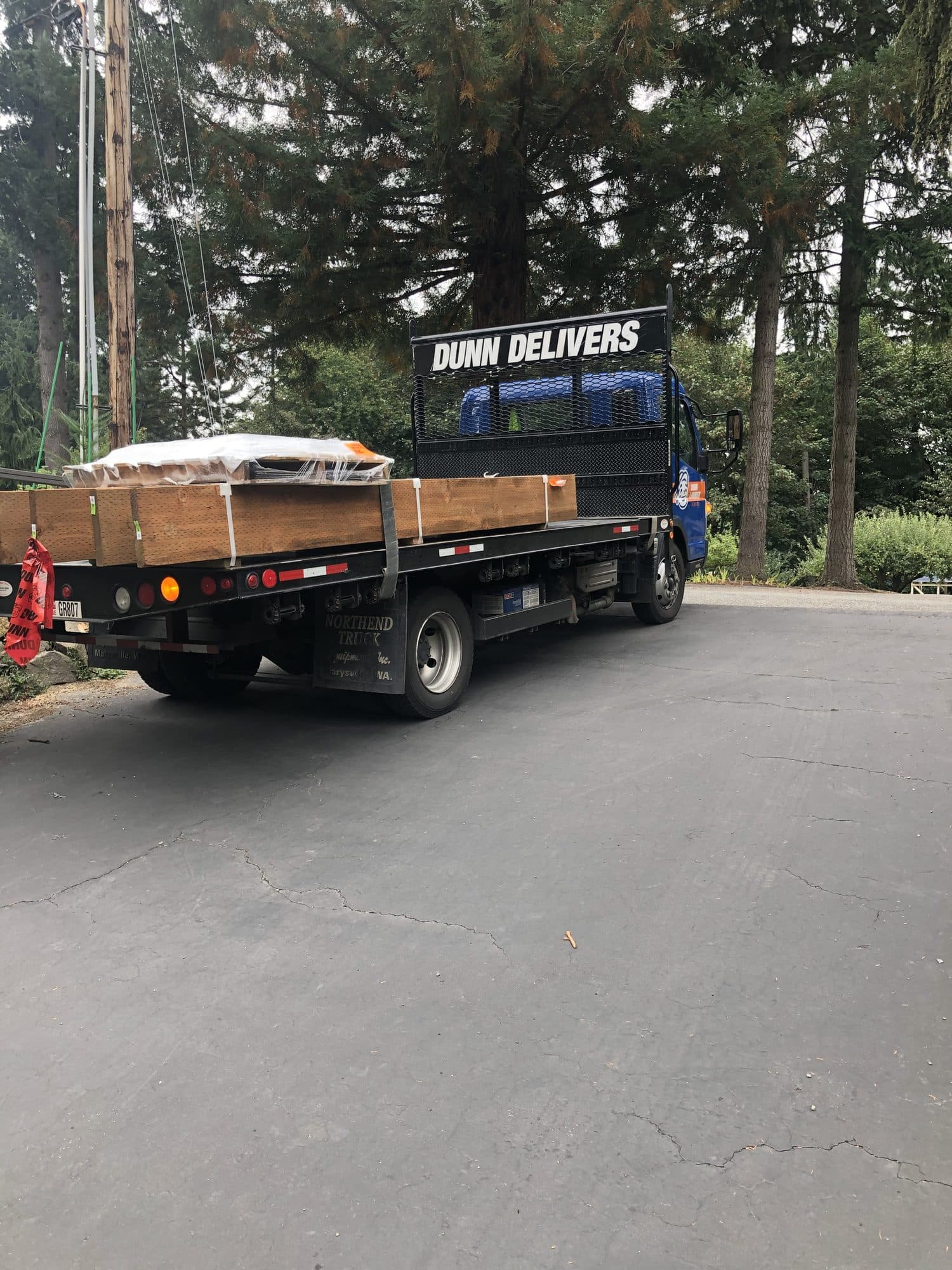 A flatbed truck delivering lumber to the street