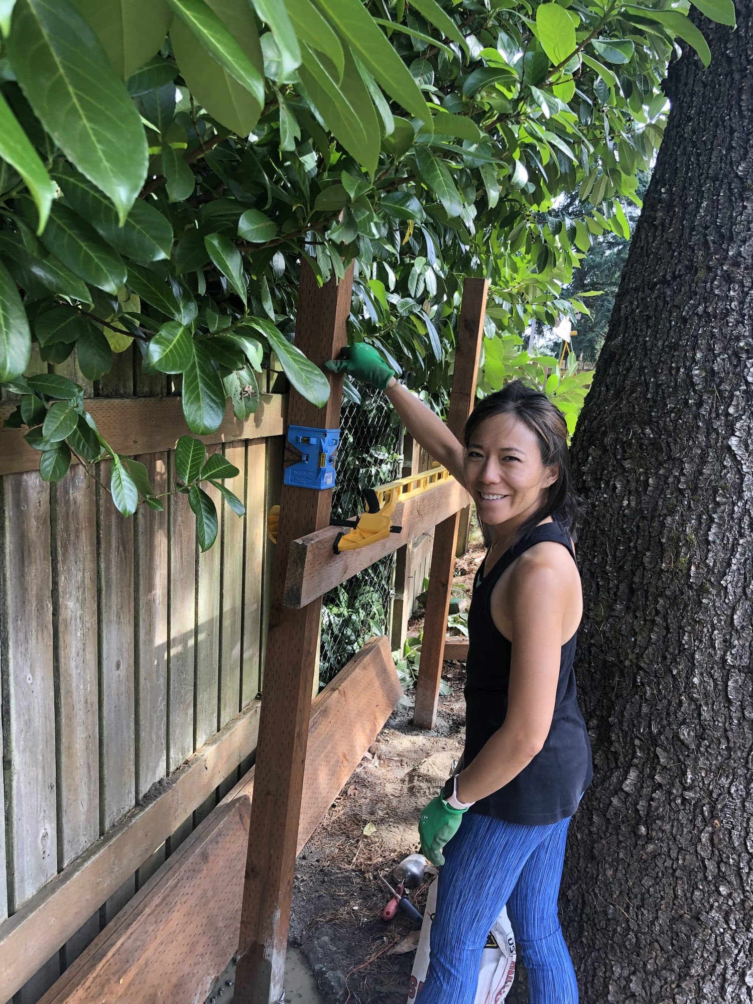 Setting the first post against the fence line, level in hand