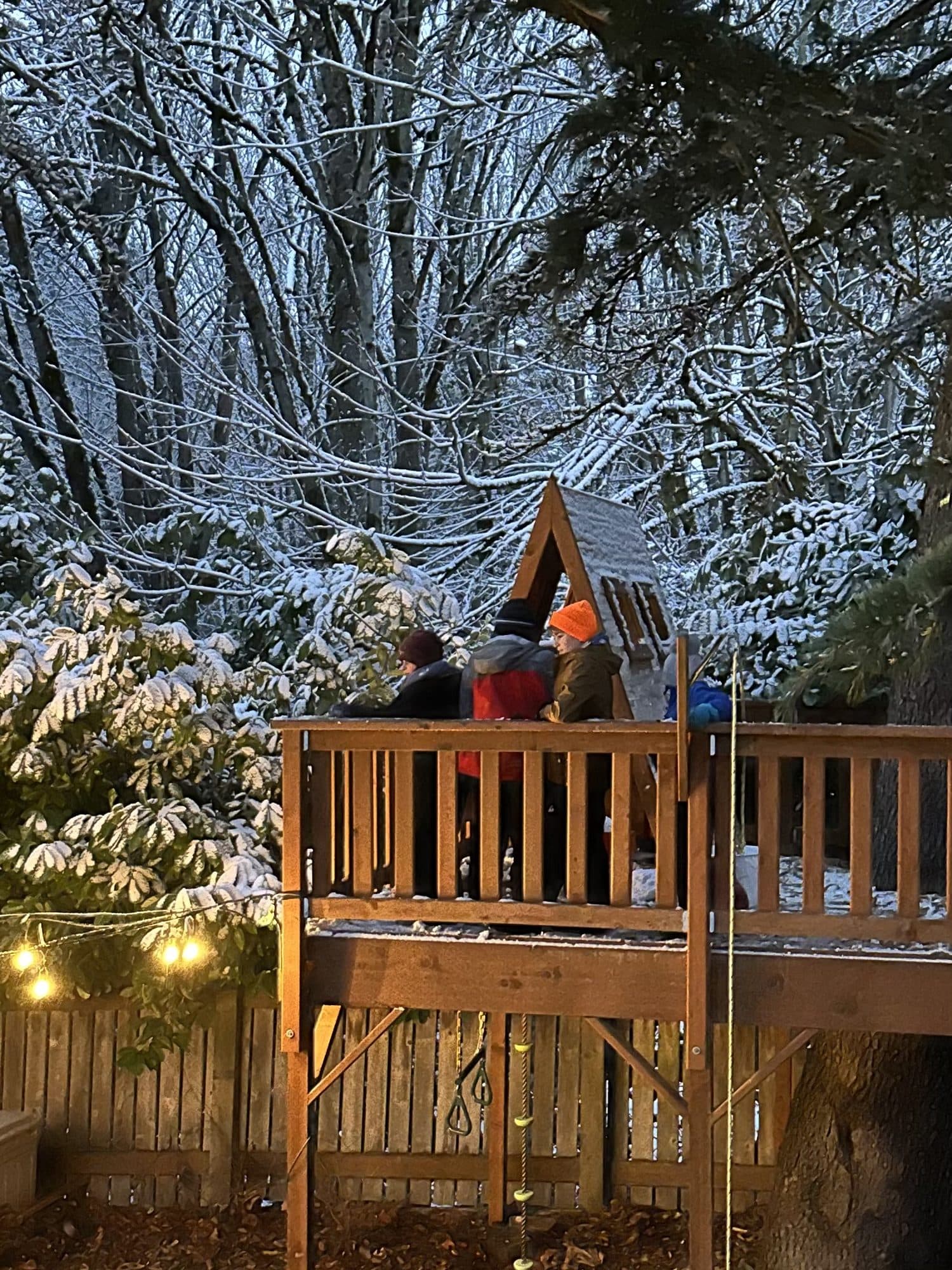 The tree house on a snowy evening, lights on